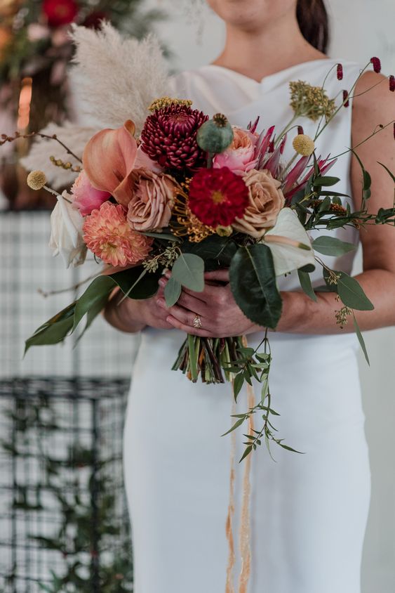 a sweet fall wedding bouquet of coffee-colroed roses, pink callas and dahlias, fuchsia chrysanthemums, greenery, grasses and ribbons