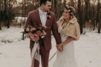 a winter groom wearing a chic mauve suit, a white shirt and a bow tie, black shoes and a blush and peach bloom boutonniere