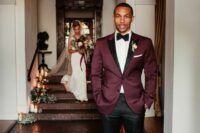 an elegant groom’s look with a white shirt, a purple blazer with black lapels, black pants and loafers