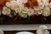 an elegant wedding centerpiece of blush roses, rust and white chrysanthemums is a chic idea