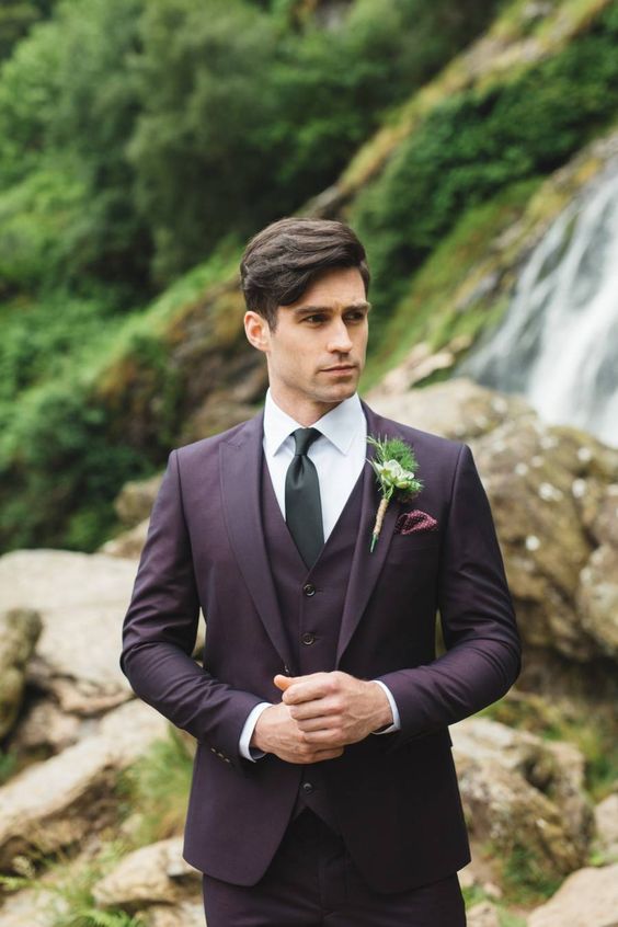 an exquisite groom's look with a purple three-piece pantsuit, a white shirt, a black tie and a greenery boutonniere