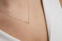 a gold frame triangle necklace on a very thin chain is a very delicate accessory to try