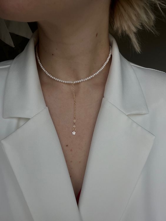 a pearl choker with a dainty chain and a pendant is a perfect addition to a pantsuit or a jumpsuit with a V-neckline