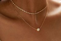 a perfect combo for a bride, a dainty gold chain necklace with a pearl and a small shiny choker are a cool solution