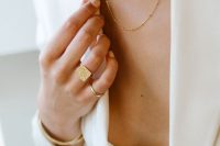 layered gold necklaces and a small bead choker are a bold solution for a modern bridal look with a pantsuit