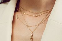 layered gold necklaces with rhinestones, beads and a large pearl will be perfect to accent a trendy modern bridal look