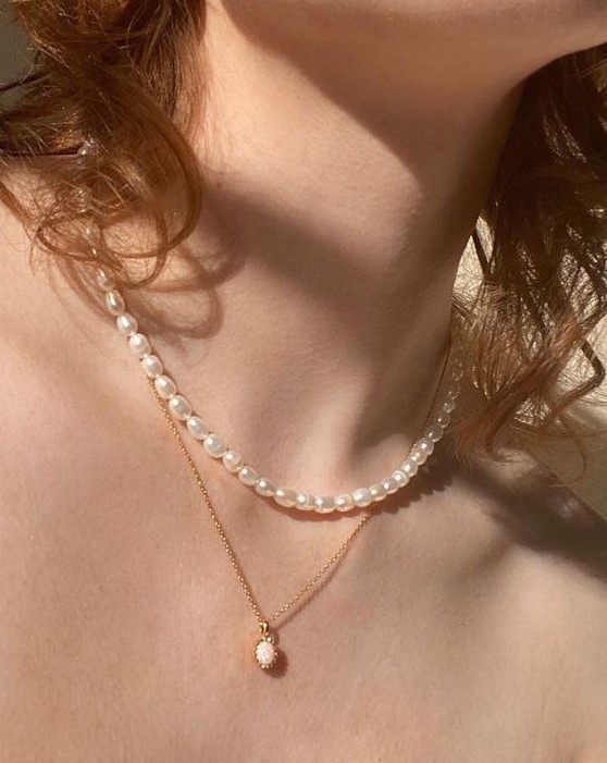 Layered necklaces   a baroque pearl one and a delicate gold chain with a pink pendant for a very feminine and delicate look