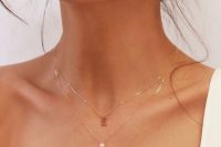 layered necklaces with a pearl and a pendant one, stacked earrings for a chic modern bridal look