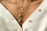 lovely layered necklaces with a monogram, a baroque pearl, a godl coin are amazing to highlight your V-neckline