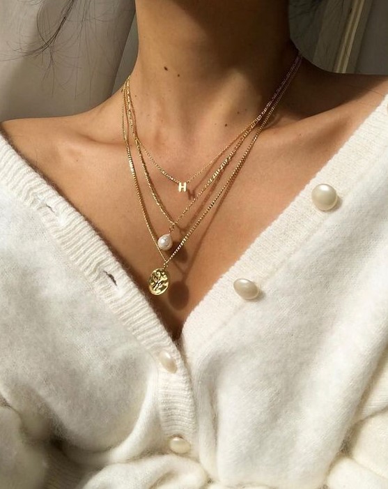 Lovely layered necklaces with a monogram, a baroque pearl, a godl coin are amazing to highlight your V neckline