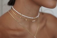 stunning layered necklaces, a pearl choker, a gold and pearl choker and a gold lariat piece plus pearl earrings for a modern and trendy bridal look