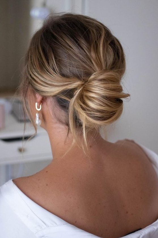 a messy chignon with a messy top and waves down is a chic modern solution without much fuss