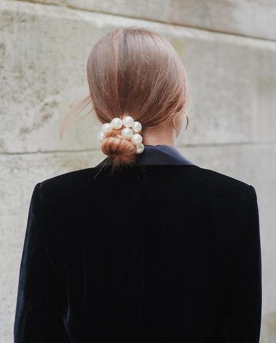 an elegant low bun with a sleek top and a pearl hair tie is a cool idea for a more formal look