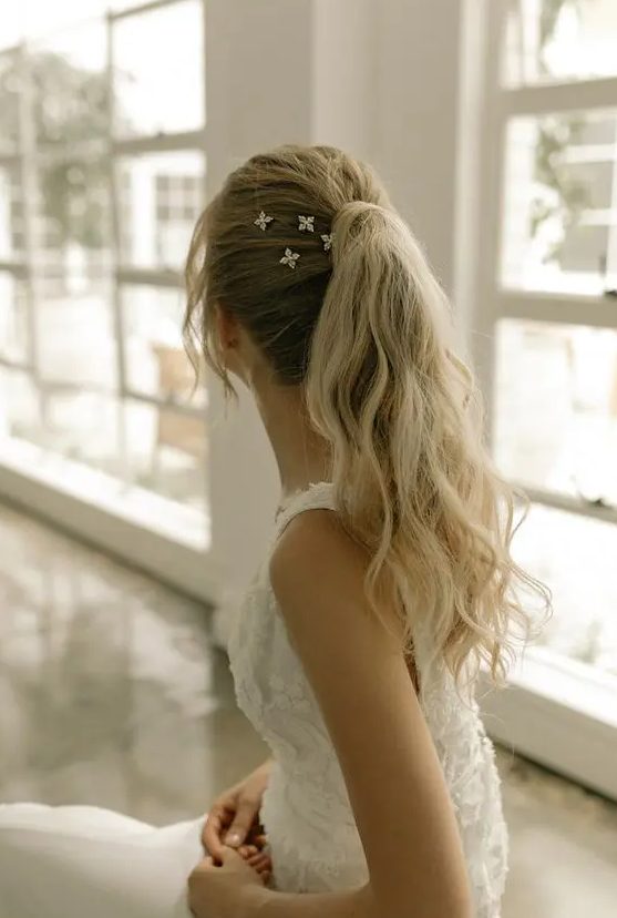 a cool messy and wavy high ponytail with a volume on top, some locks down, stars accenting the hairstyle