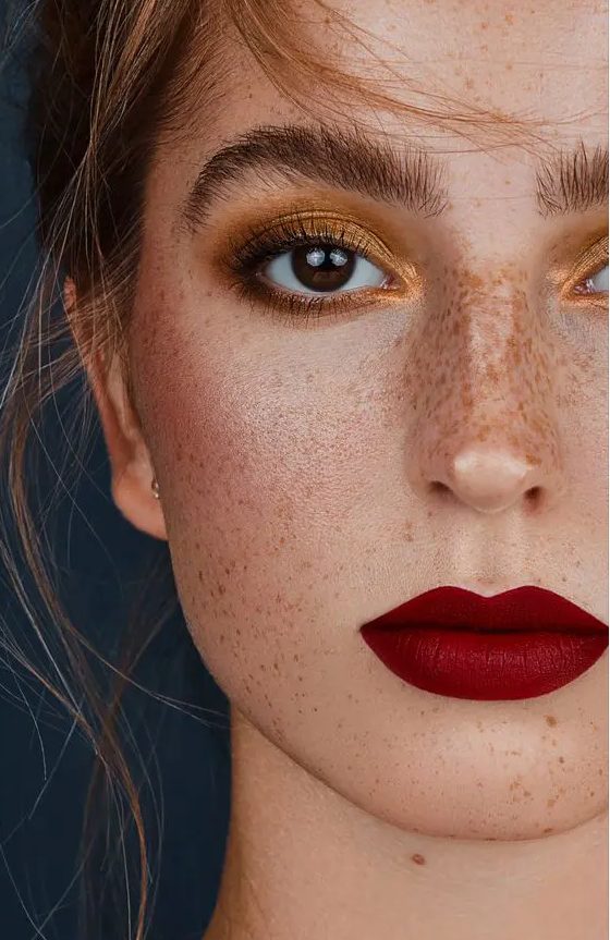 a bold makeup with a gold smokey eye and red lips is fantastic for a bold bridal look, especially a Christmas one