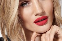 a catchy holiday wedding makeup with a red lpi, a perfect skin tone and everything else done in a very delicate way to accent the lips
