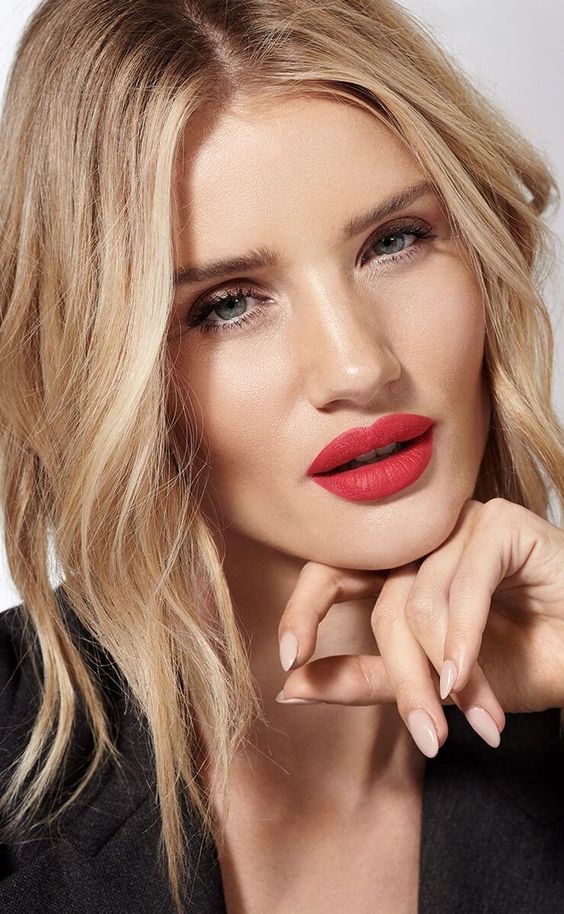 a catchy holiday wedding makeup with a red lpi, a perfect skin tone and everything else done in a very delicate way to accent the lips
