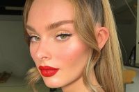 a catchy wedding makeup with a red lip and a lot of blush plus some highlighter as if you have just come back from the beach