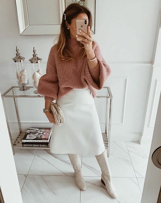 a girlish winter work look with a pink chunky sweater, a white A-line midi skirt, white boots and a clutch is a lovely and cool outfit