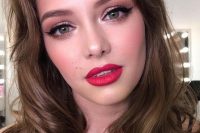 a glam holiday wedding makeup with a red lip, a touch of blush, perfect tone with highlighter, wings