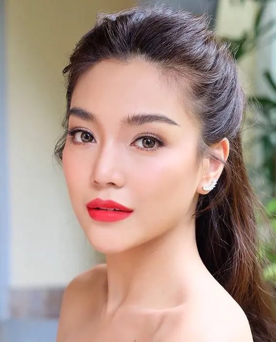 a gorgeous bold Asian makeup with a matte red lip, extended eyelashes, chic eyebrows and blushes looks amazing