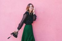 a lovely winter guest outfit with a black polka dot blouse, a green pleated midi skirt, black shoes and a bag
