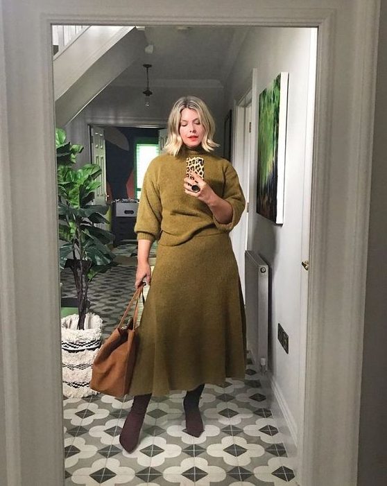 A refined look with a knit set with a moss green sweater and a matching A line midi skirt, an amber bag and purple boots