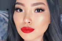 an ideal holiday wedding makeup with a glossy red lip, a perfect tone with highlighter, lash extensions, statement eyebrows