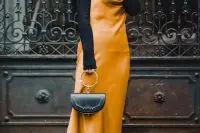 black sock boots, a black turtleneck, a marigold slip midi dress and a black bag on a ring for a refined feminine look