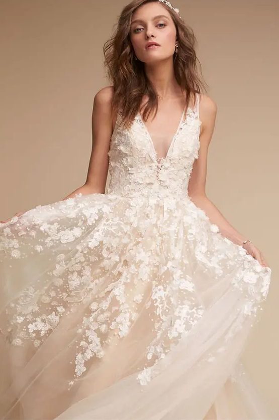 a sheer tulle panel at the neckline and a dreamy ball skirt silhouette with white floral appliques