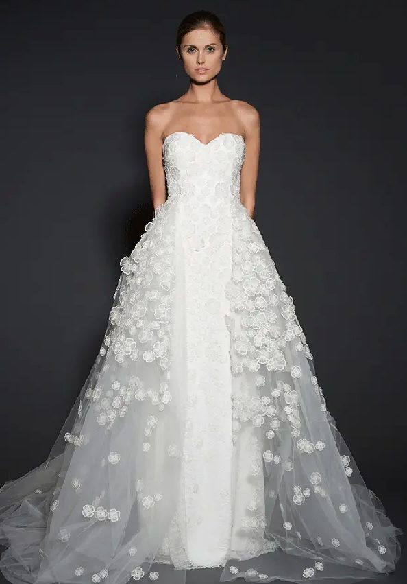 a floral lace applique sheath wedding dress with an additional tulle overskirt for the ceremony