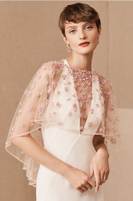 a super delicate sheer cover up with pink 3D flowers on is a cool and chic accessory for a bride