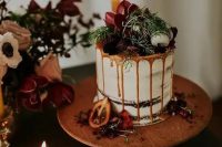 15 a chocolate naked wedding cake with caramel drip, fresh berries and dark blooms, macarons and greenery