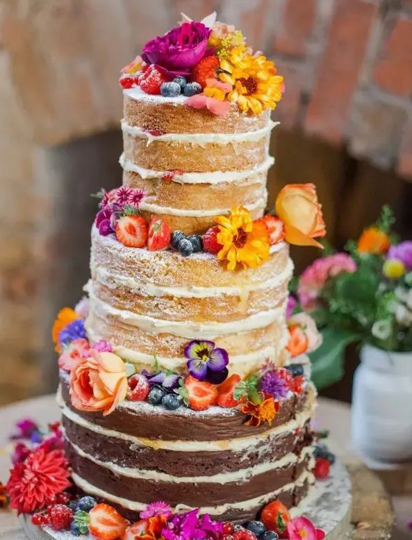 a colorful naked wedding cake topped with bright blooms and berries is a fantastic idea for a summer boho wedding with plenty of color