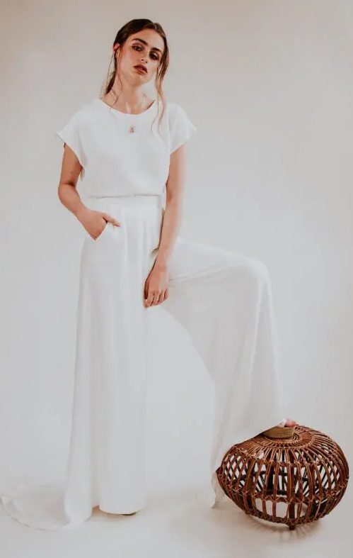 a 70s inspired bridal look with a white plain top with cap sleeves and wideleg pants with a train that remind of a skirt