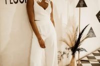 18 a bold and catchy bridal look with high waisted wideleg pants, a crop top with thick straps and a deep neckline, sneakers and oversized earrings