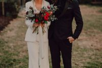 22 a modern boho bride wearing a white pansuit with a white shirt, a white hat and platform heels