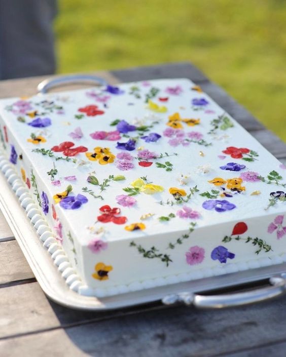 a white sheet wedding cake with colorful pressed flowers is a super cool idea for a spring or summer wedding