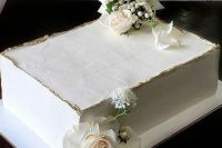 28 a white sheet wedding cake with a gold edge and fresh white blooms is pure elegance