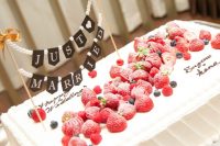 29 a sheer wedding cake topped with fresh berries and a bunting is a cool idea for a summer wedding