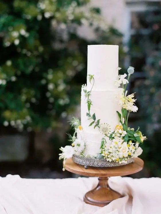 a chic secret garden wedding cake in white, with fresh white and yellow blooms and greenery is a lovely idea for a relaxed garden wedding