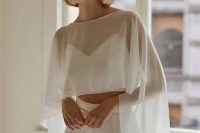 33 a creative modern bridal look with a crop top, high waisted pants, a sheer high low bridal capelet is wow