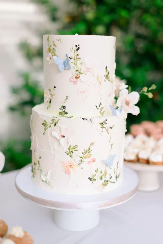 a neutral wedding cake decorated with pastel flowers and butterflies of sugar is amazing for a spring wedding