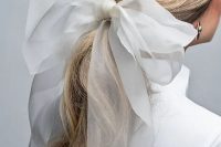 44 a twisted low ponytail accented with a large bow is a very glam and fresh idea for a modern bride