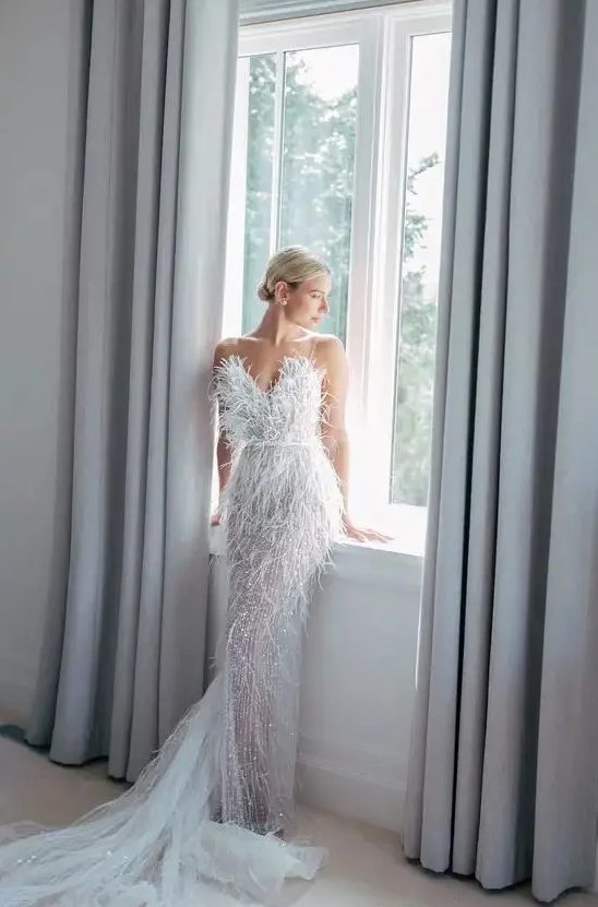 a jaw-dropping feather embellished wedding dress with a sweetheart neckline and a train is amazing for an art deco bride