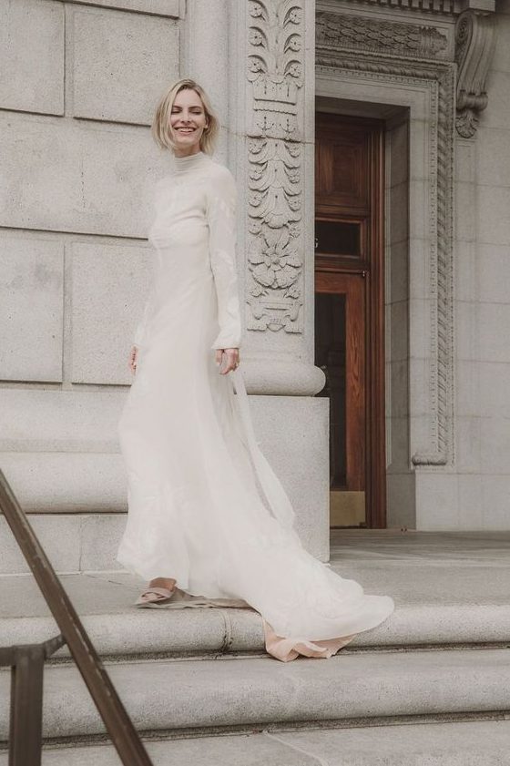 a turtleneck lace sheath wedding dress with long sleeves and a train for a modern and modest bride