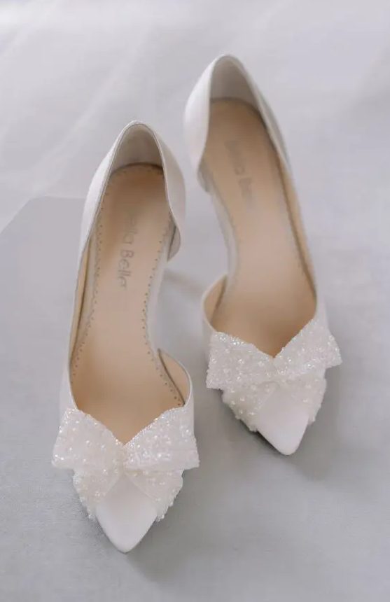 beautiful white wedding shoes with shiny pearl bows are a fresh take on traditional, a new way to wear pearls at a wedding