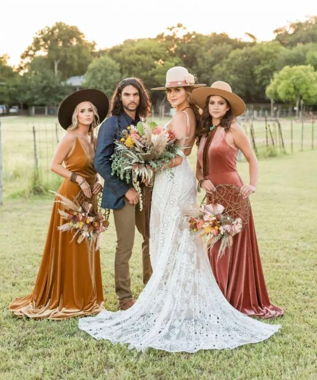 mismatching mustard and burnt orange maxi bridesmaid dresses and hats for a fall boho wedding