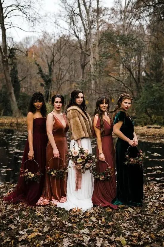 mismatching rust, burgundy and emerald maxi bridesmaid dresses of velvet and plain fabric are a great solution for a boho fall wedding