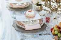 04 an exquisite wedding tablescape with a lace tablecloth, pastel blue candles, pastel florals and elegant porcelain and delicious sweets